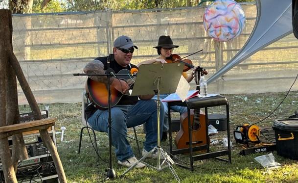 Man playing guitar with woman playing violin